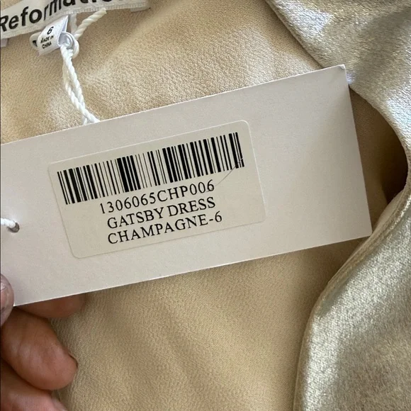 This is a Reformation Gatsby Dress in a silver or champagne color new with tags